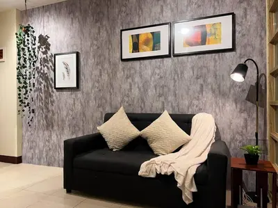 a living room with a black couch with a blanket on it at 1BR Condotel Ridgewood Towers Taguig City #RW11 in Manila