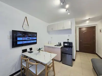 a kitchen with a table and a small kitchen with a stove at 1BR Condotel Ridgewood Towers Taguig City #RW14 in Manila