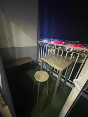 a table and stool on a balcony at night at Mall of Asia view from Balcony 15F in Manila