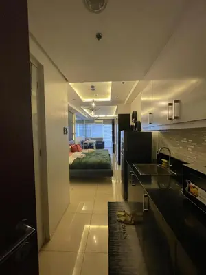 a kitchen with a sink and a bed in a room at Mall of Asia view from Balcony 15F in Manila