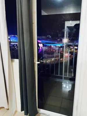 an open window with a view of a city at night at Mall of Asia view from Balcony 15F in Manila