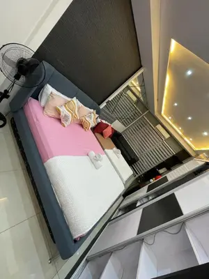 a small bed in a box with a laptop on it at Mall of Asia view from Balcony 15F in Manila