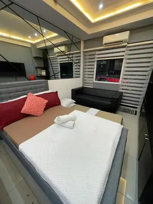 a large bed in a room with a couch at Mall of Asia view from Balcony 15F in Manila