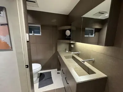 a bathroom with a toilet and a sink and a mirror at Dazzling fully furnished unit BGC w Pool in Manila