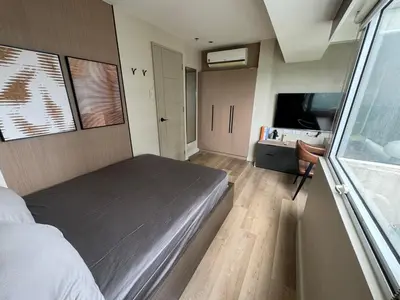 a bedroom with a bed and a television in it at Dazzling fully furnished unit BGC w Pool in Manila