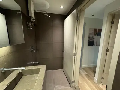 a bathroom with a shower with a sink and a mirror at Dazzling fully furnished unit BGC w Pool in Manila