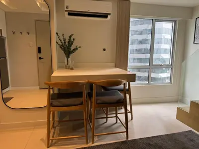 a kitchen with a table and chairs and a mirror at Dazzling fully furnished unit BGC w Pool in Manila