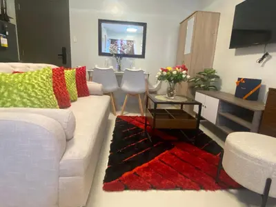 a living room with a white couch and a red rug at Kral Suite in Las Piñas in Manila