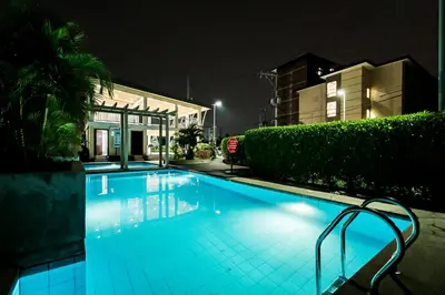 a large swimming pool at night with a building at Kral Suite in Las Piñas in Manila