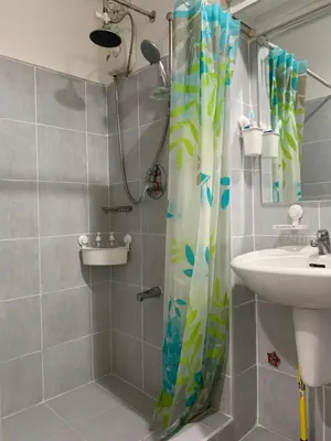 a bathroom with a shower curtain and a sink at Your Happy Home in Mall of Asia in Manila