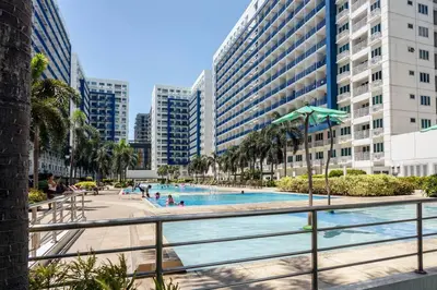a swimming pool in a city with tall buildings at Your Happy Home in Mall of Asia in Manila