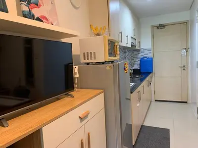 a kitchen with a refrigerator and a microwave on a counter at Your Happy Home in Mall of Asia in Manila