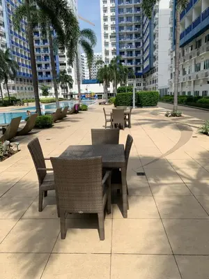 a patio with a table and chairs and buildings at Your Happy Home in Mall of Asia in Manila