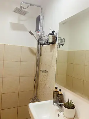 a bathroom with a sink and a shower with a mirror at Beans Crib Staycation at SMDC Green 2 Residences in Dasmariñas