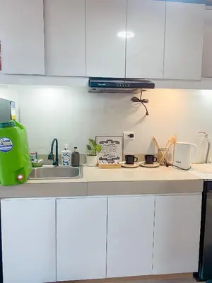 a kitchen with white cabinets and a sink at Beans Crib Staycation at SMDC Green 2 Residences in Dasmariñas