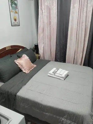 a bedroom with a bed with two towels on it at Nice condotel in Manila