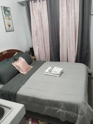a bedroom with a bed with two towels on it at Nice condotel in Manila