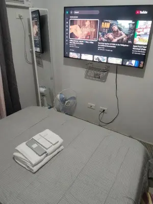 a hospital room with a bed with a tv on the wall at Nice condotel in Manila