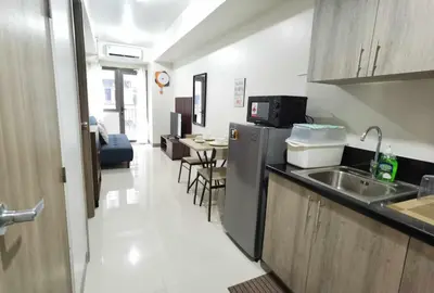 a kitchen with a sink and a table with chairs at S Residences in Manila