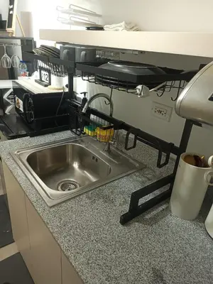 a kitchen counter with a sink and a microwave at La Maison d'Antoine in Manila