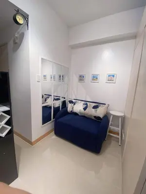 a bedroom with a blue bed and a mirror at La Maison d'Antoine in Manila