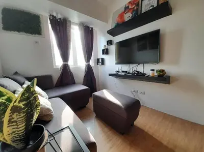 a living room with a couch and a flat screen tv at Condo In Manila in Manila