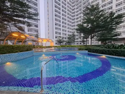 a large swimming pool in a building with tall buildings at Grace Tower 3 in Manila
