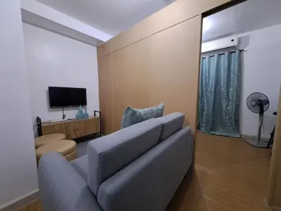 a living room with a couch and a television at Grace Tower 3 in Manila
