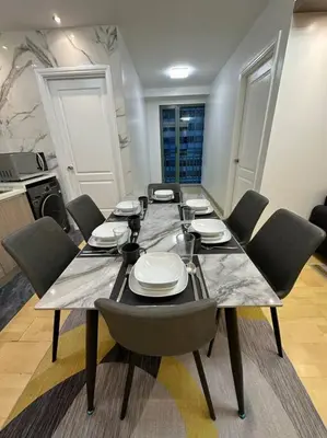 a dining room table with chairs and plates on it at Spacious 2-bedroom Corner Unit across Shangri-La in Manila