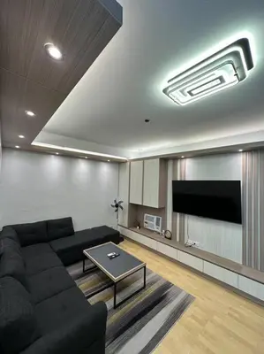 a living room with a couch and a flat screen tv at Spacious 2-bedroom Corner Unit across Shangri-La in Manila