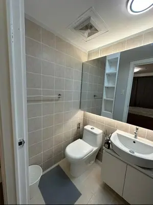 a bathroom with a toilet and a sink at Spacious 2-bedroom Corner Unit across Shangri-La in Manila
