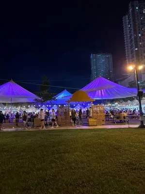 a group of people walking under purple umbrellas at night at Spacious 2-bedroom Corner Unit across Shangri-La in Manila