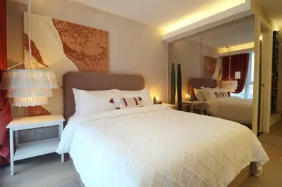 a bedroom with a large white bed and a mirror at Luxury Oasis in Makati with Balcony in Manila