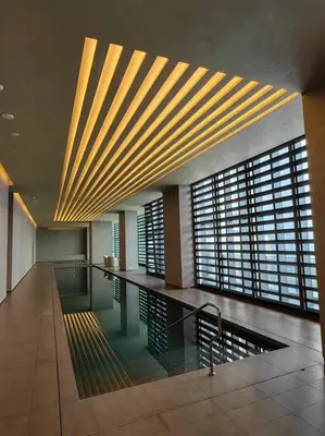 a lobby with a pool in the middle of a building at Luxury Oasis in Makati with Balcony in Manila