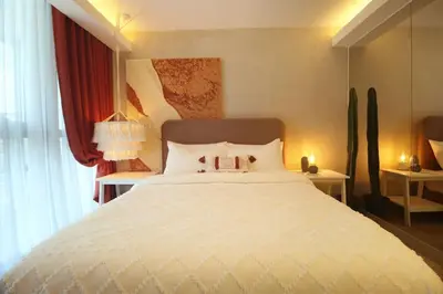 a bedroom with a large white bed with two lamps at Luxury Oasis in Makati with Balcony in Manila