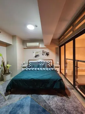 a bedroom with a large green bed in it at Eastwood LeGrand 3 Eastwood City, Quezon City in Manila