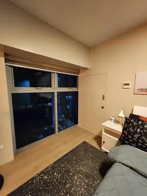 a bedroom with a bed and a large window at Eastwood LeGrand 3 Eastwood City, Quezon City in Manila