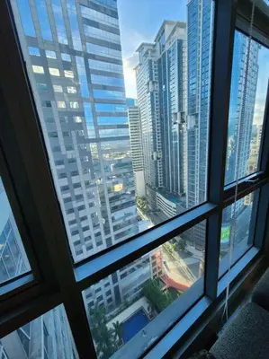 a view of a city skyline from a window at Eastwood LeGrand 3 Eastwood City, Quezon City in Manila