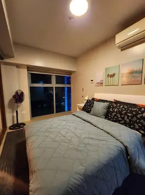 a bedroom with a large bed and a window at Eastwood LeGrand 3 Eastwood City, Quezon City in Manila