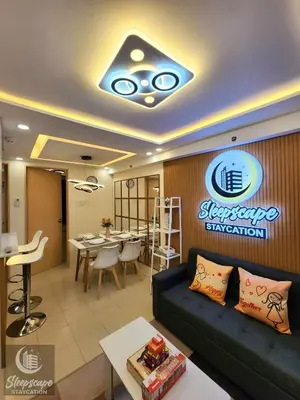 a living room with a couch and a dining room at SleepScape Staycation in Manila