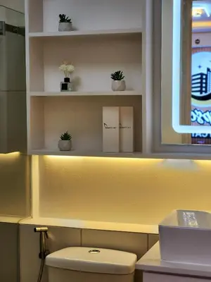 a bathroom with a toilet and shelves with plants at SleepScape Staycation in Manila
