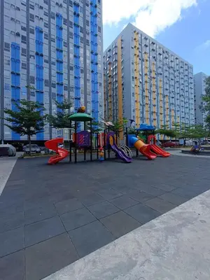 a playground in a park with tall buildings at SleepScape Staycation in Manila