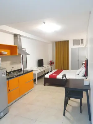 a hotel room with a bed and a kitchen at Travel time suites bel air soho in Manila