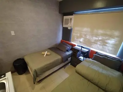 a small room with two beds and a window at Affordable Studio 2 Twin Beds - City View EDSA in Manila