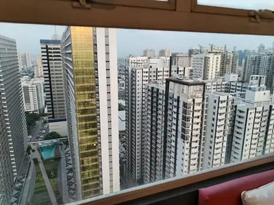 a view of a large city from a window at Affordable Studio 2 Twin Beds - City View EDSA in Manila