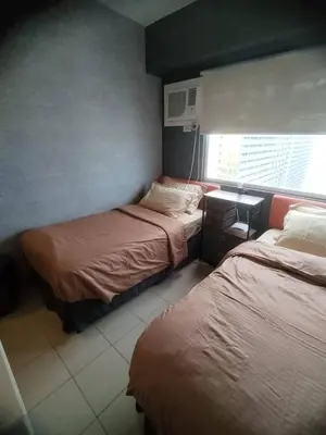 a hotel room with two beds and a window at Affordable Studio 2 Twin Beds - City View EDSA in Manila