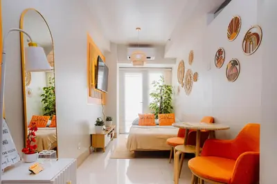 a room with a bed and a table and chairs at Oranje Suite near NAIA AIRPORT in Manila