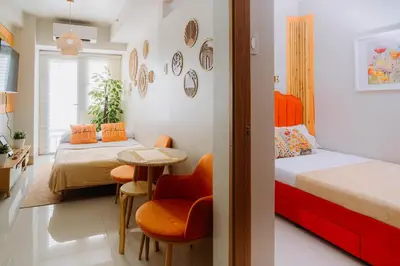 a bedroom with two beds and a table and chairs at Oranje Suite near NAIA AIRPORT in Manila