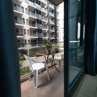 a balcony with a table and chairs and a building at LDN Secret Crib PALM TREE Across NAIA T3 in Manila