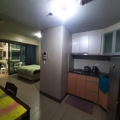 a room with a kitchen and a bedroom with a bed at LDN Secret Crib PALM TREE Across NAIA T3 in Manila